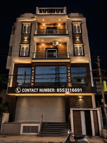 a building with a sign that reads contact number at Sofra service apartment by LUXE with swinging pool in Mysore