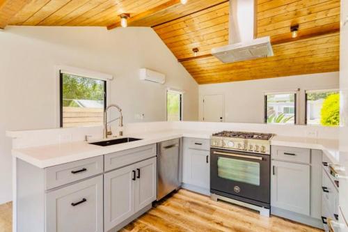 a kitchen with white cabinets and a wooden ceiling at Downtown Ojai Gem in Ojai