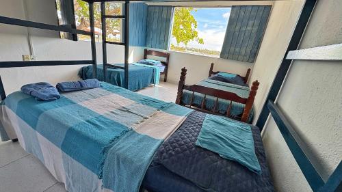 a bedroom with two beds and a window at Xodó da Lagoa in Beberibe