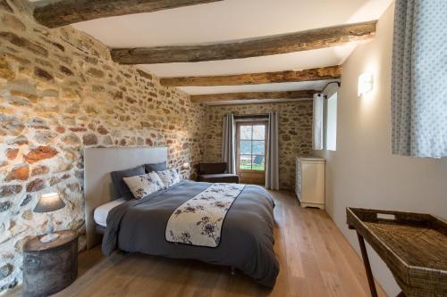 a bedroom with a stone wall and a bed in a room at Domaine de Gressac in Verfeuil