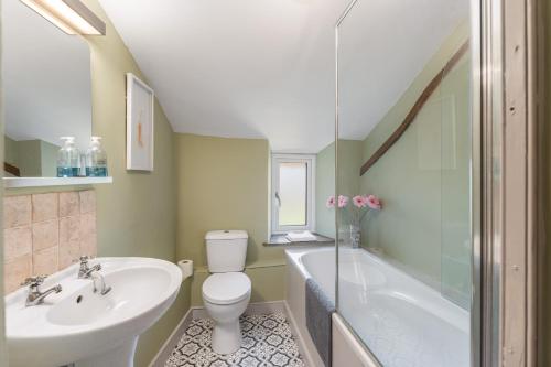 a bathroom with a sink and a toilet and a tub at Malvern House in Banbury