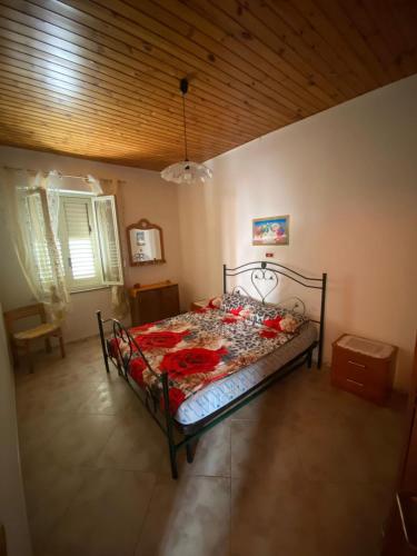 a bedroom with a bed with red flowers on it at B&B da Alessandro in Palmi