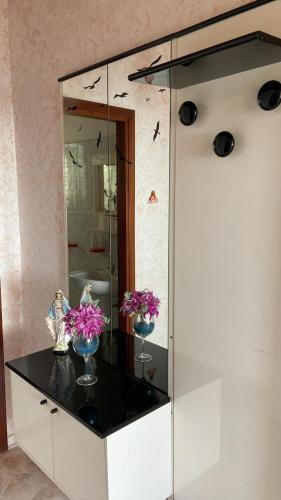 a glass cabinet with two vases with flowers in it at B&B da Alessandro in Palmi