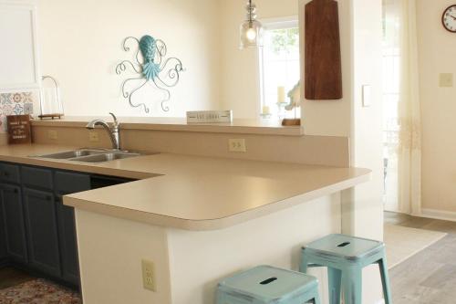a kitchen with a sink and a counter with two stools at CoastalBoho-Spacious 4BDtownhouse 3 mi from beach in Rehoboth Beach