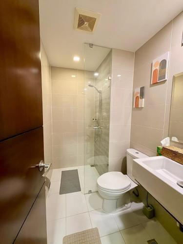 a bathroom with a toilet and a shower and a sink at McBride Suites in Punta Engaño