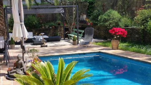 une arrière-cour avec une piscine et une terrasse avec une table dans l'établissement La Douce Heure, à Mougins
