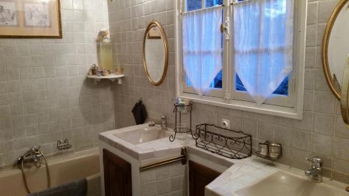 a bathroom with a sink and a tub and a mirror at La Douce Heure in Mougins