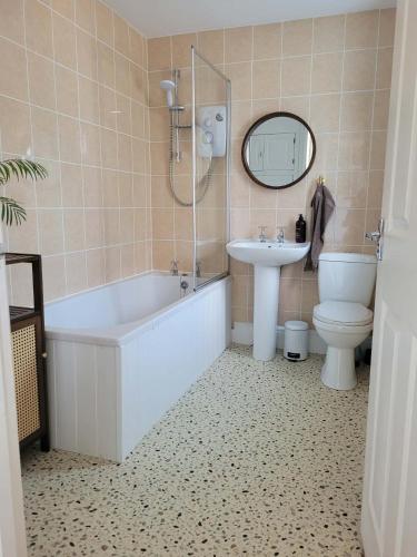 a bathroom with a tub and a sink and a toilet at Brent Top in Penrith