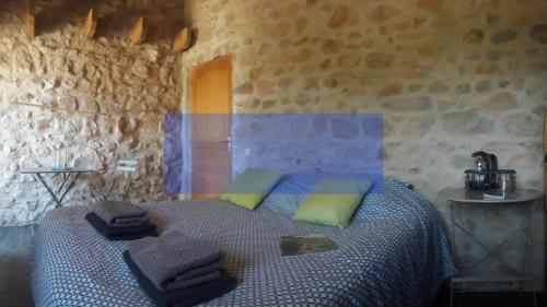 a bedroom with a bed in a stone wall at Nuit pour 4 en Auvergne in Vallon-en-Sully