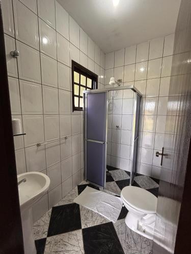 a bathroom with a shower and a toilet and a sink at Hotel Harmonia Sarapuí in Sarapuí
