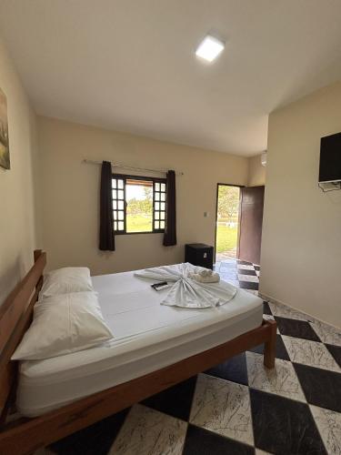 a large bed in a room with a window at Hotel Harmonia Sarapuí in Sarapuí