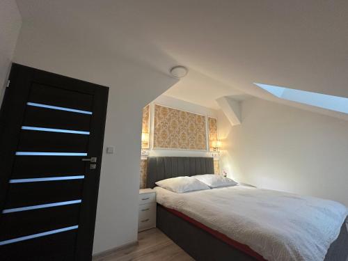 a bedroom with a bed in a white room at Apartmány Tonny in Jáchymov