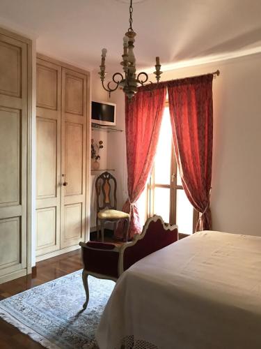a bedroom with a bed and a chair and a window at Casa Olivi, Fermo in Fermo