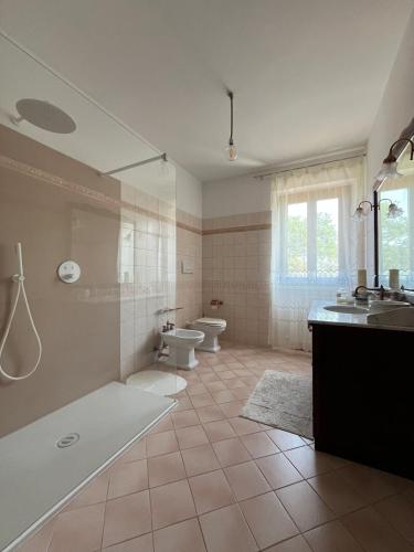 a bathroom with two toilets and a tub and a sink at Casa Olivi, Fermo in Fermo