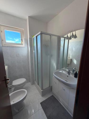 a bathroom with two toilets and a sink and a shower at Riva Bianca in Ameglia