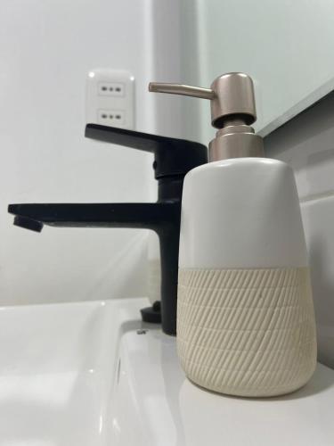 a bathroom sink with a faucet and a soap dispenser at Ingloo in Puerto Natales