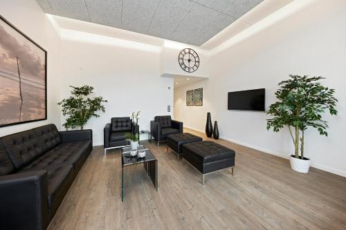 a living room with couches and a clock on the wall at Living Suites in Nærum