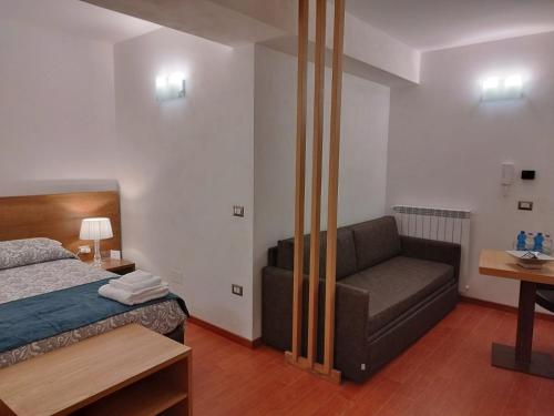 a bedroom with a bed and a couch at B&B Il Prugnolo in Castel di Sangro