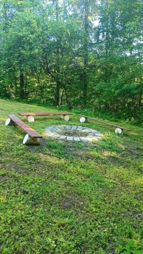 a group of benches sitting in the grass at Pogórzański Domek in Ciężkowice