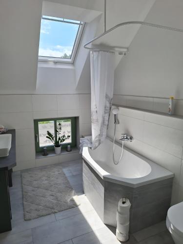 a white bathroom with a tub and a toilet at Zillestuben Altenburg in Altenburg