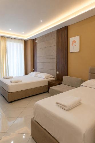 a hotel room with two beds and a couch at AMMEN Rooms in Shëngjin