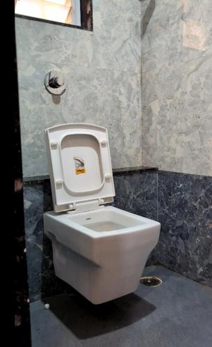 a toilet with the seat up in a bathroom at Hotel Sai Vandan in Nagpur