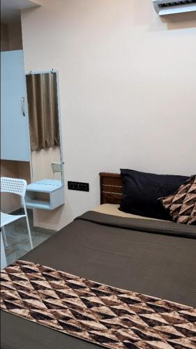 a bedroom with a bed and a mirror and a chair at Hotel Sai Vandan in Nagpur