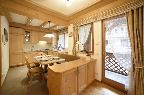 a kitchen with a wooden table and a dining room at Romantic Chalet Dolomiti in Val di Zoldo