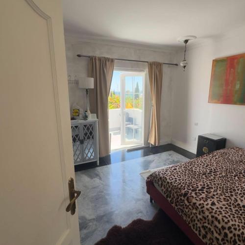 a bedroom with a bed and a door to a balcony at Room in Estepona