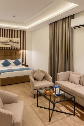 a bedroom with a bed and a living room at سراة للشقق الفندقية in Al Namas