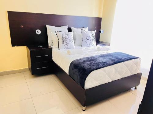 a bedroom with a large bed with a wooden headboard at MrP Guest House in Kokstad