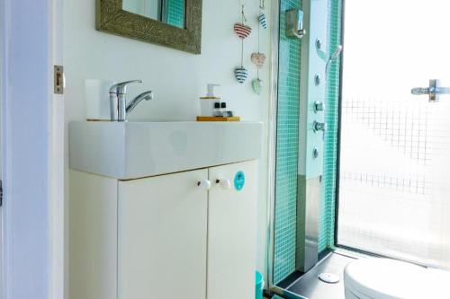 a bathroom with a sink and a shower at SLEEPBOAT Floating House Boat Oporto Douro in Porto