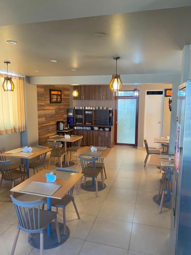 a restaurant with tables and chairs and a kitchen at Hotel Dubái in Tacna
