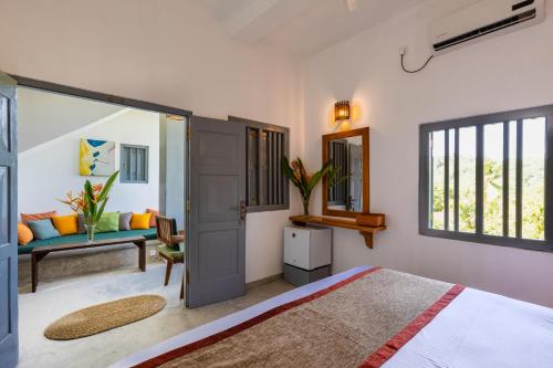 a bedroom with a bed and a couch and a window at Old Chilli House in Unawatuna