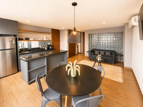 a kitchen and living room with a table and chairs at Modernos departamentos tipo LOFT a dos calles del estadio in Boca del Río
