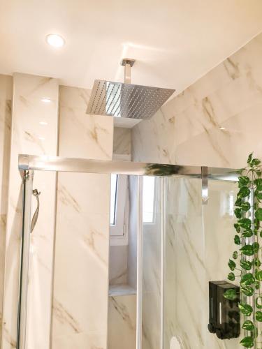 a bathroom with a shower with marble walls at Belvedere Penthouse Suite in Tríkala