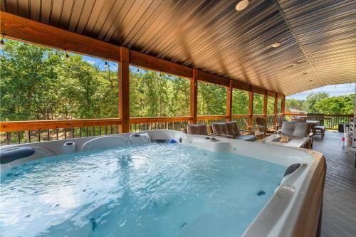 a large jacuzzi tub on a porch with windows at Lumberjack Lodge with Amenities in Hollister