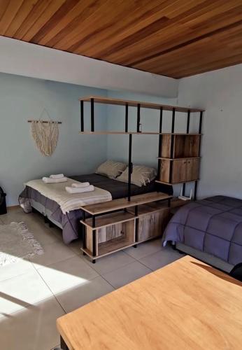 a bedroom with two beds and a wooden ceiling at Dpto General Roca 1355 - La Loggia in San Martín de los Andes