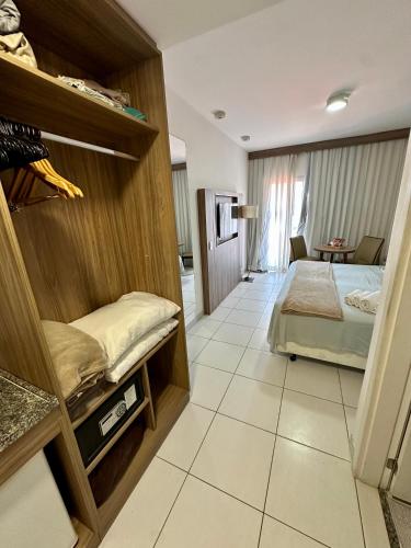 a bedroom with a bed and a room with at Flat em hotel Promenade Itaguaí in Itaguaí