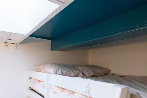 a bed in a room with a blue ceiling at Chic Studio Apartment for 3 - La Villette! in Paris