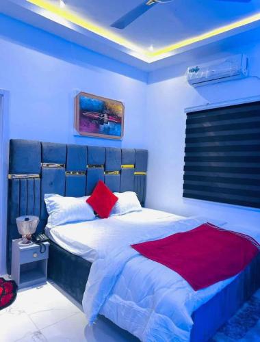 a bedroom with a bed with a red blanket at MyTime Hotel in Tamale