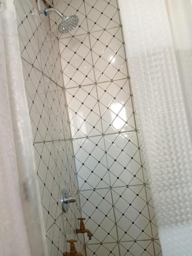 a shower with a white tiled ceiling in a bathroom at Uptown Inn GuestHouse in Parys