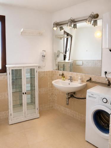 a bathroom with a sink and a washing machine at Residence Borgo Punta Villa in La Maddalena