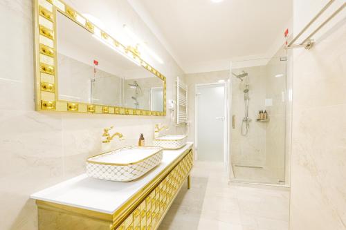 a bathroom with two sinks and a shower at In Grand Hotel & SPA in Bucharest