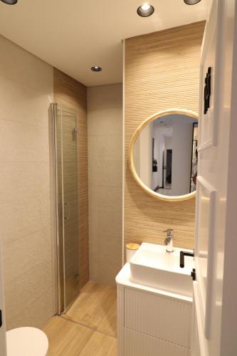 a bathroom with a sink and a mirror at Tinico's Guest Rooms in Nazaré
