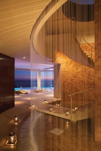 a lobby with a spiral staircase and a building at Secrets Huatulco Resort & Spa in Santa Cruz Huatulco
