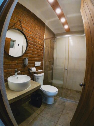 a bathroom with a sink and a toilet and a mirror at Santuario San Agustín in Bajo de Arenal