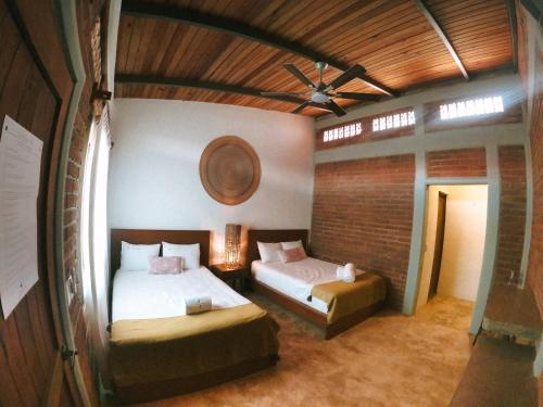 a bedroom with two beds and a ceiling fan at Santuario San Agustín in Bajo de Arenal
