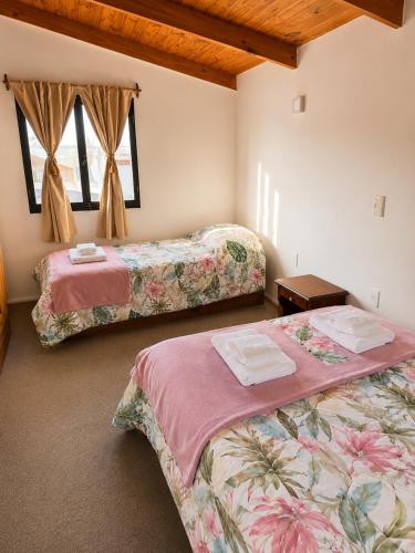 a bedroom with two beds and a window at Miniloft Centrico in El Calafate