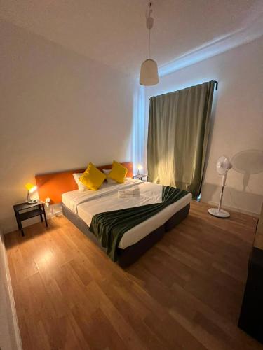 a bedroom with a bed with yellow pillows at 7 Requinte HOSTel in Lisbon